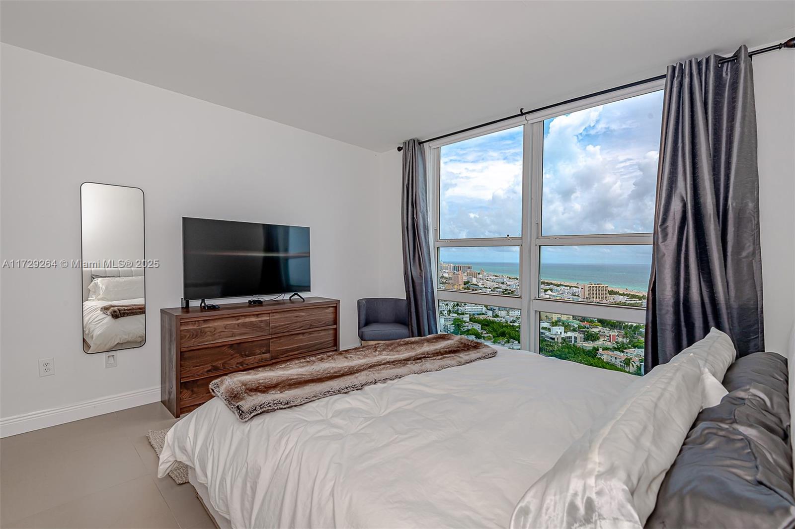 90 Alton Road, Unit PH3205 Miami Beach, FL 33139 - Photo 15 of 28 a bedroom with a bed and a large window