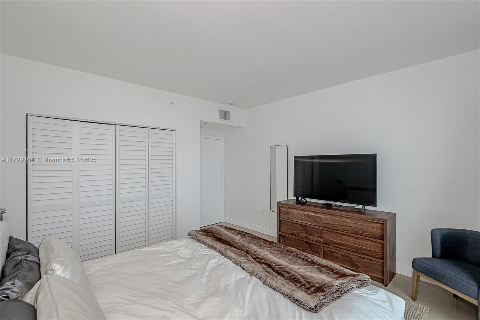 90 Alton Road, Unit PH3205 Miami Beach, FL 33139 - Photo 18 of 28 a bedroom with a bed and a television