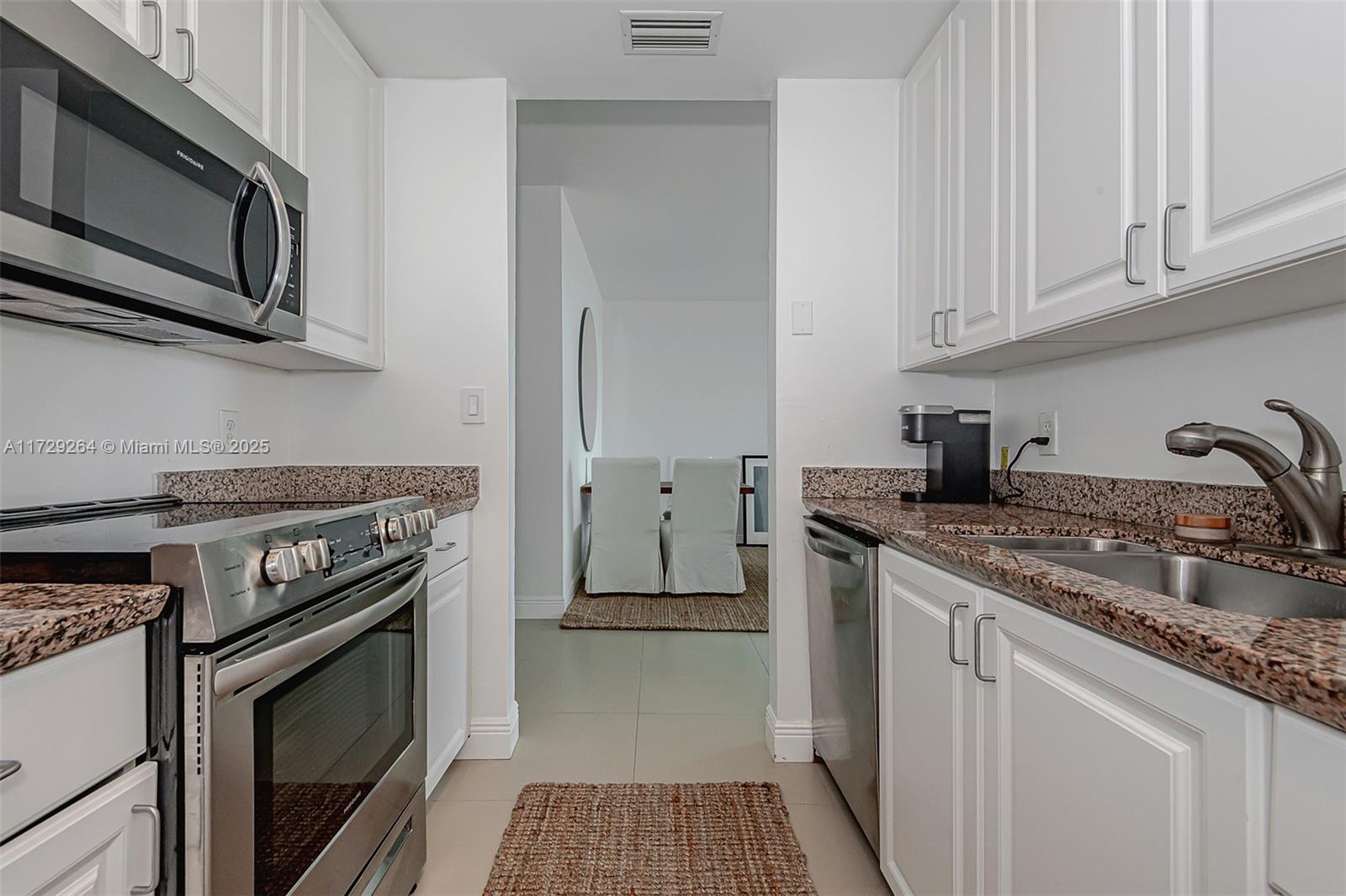 90 Alton Road, Unit PH3205 Miami Beach, FL 33139 - Photo 19 of 28 a kitchen with stainless steel appliances granite countertop a stove microwave and sink