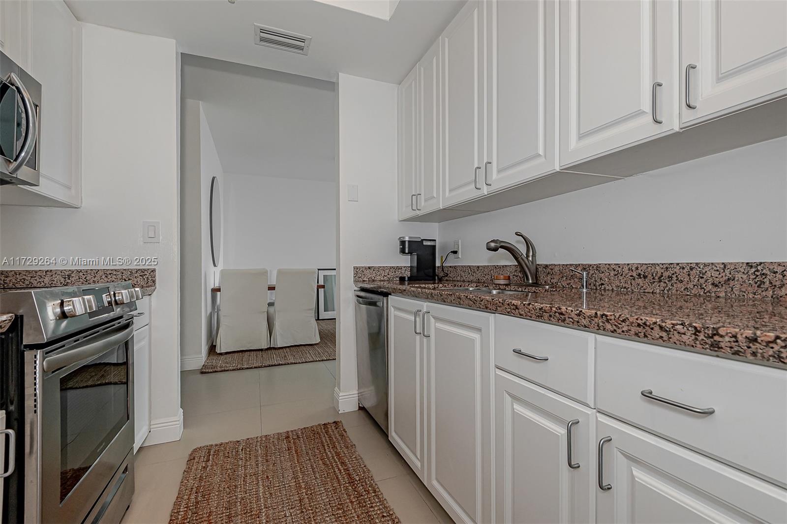 90 Alton Road, Unit PH3205 Miami Beach, FL 33139 - Photo 20 of 28 a kitchen with granite countertop white cabinets stainless steel appliances and sink