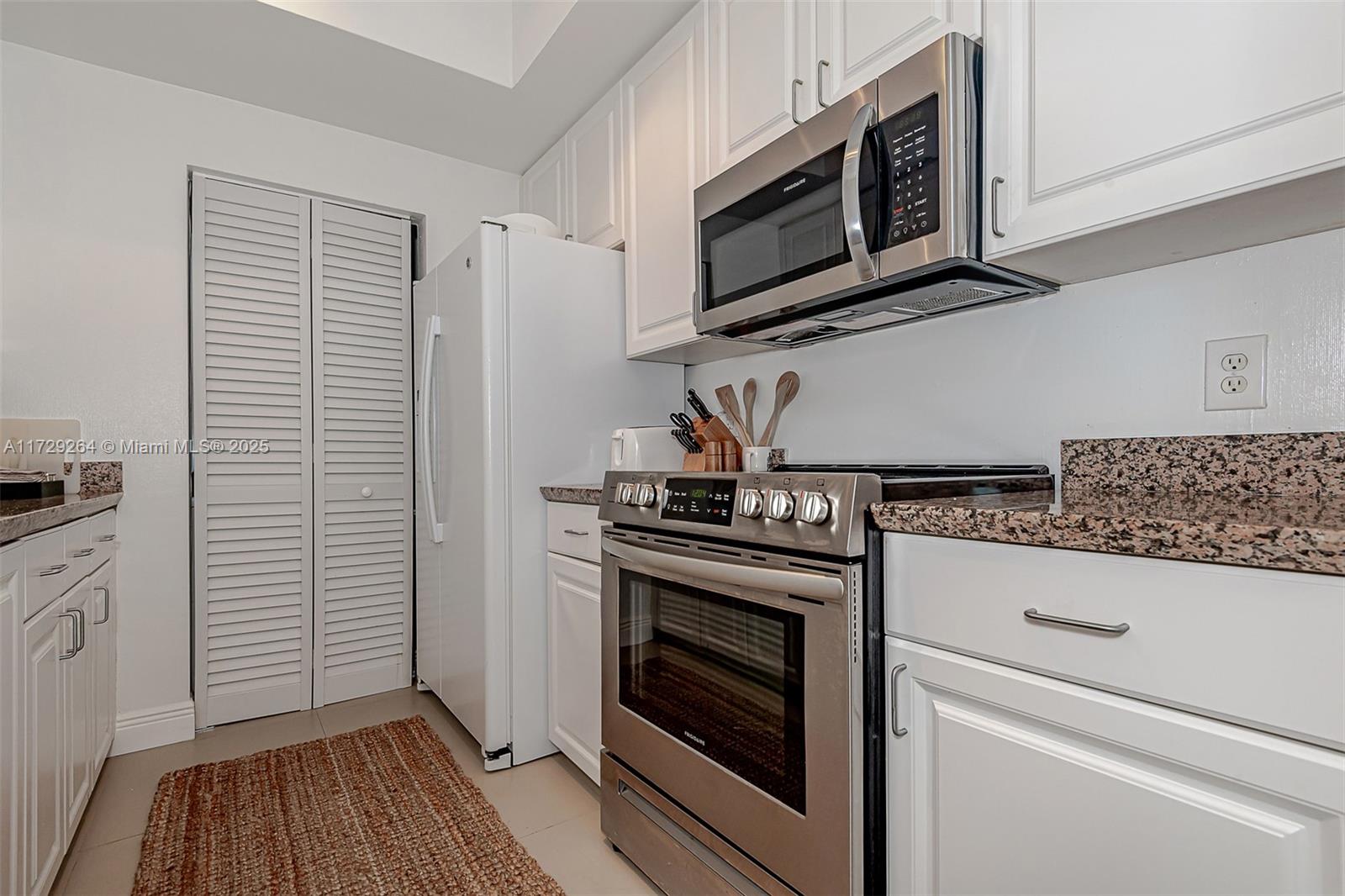 90 Alton Road, Unit PH3205 Miami Beach, FL 33139 - Photo 22 of 28 a kitchen with granite countertop cabinets stainless steel appliances and wooden floor