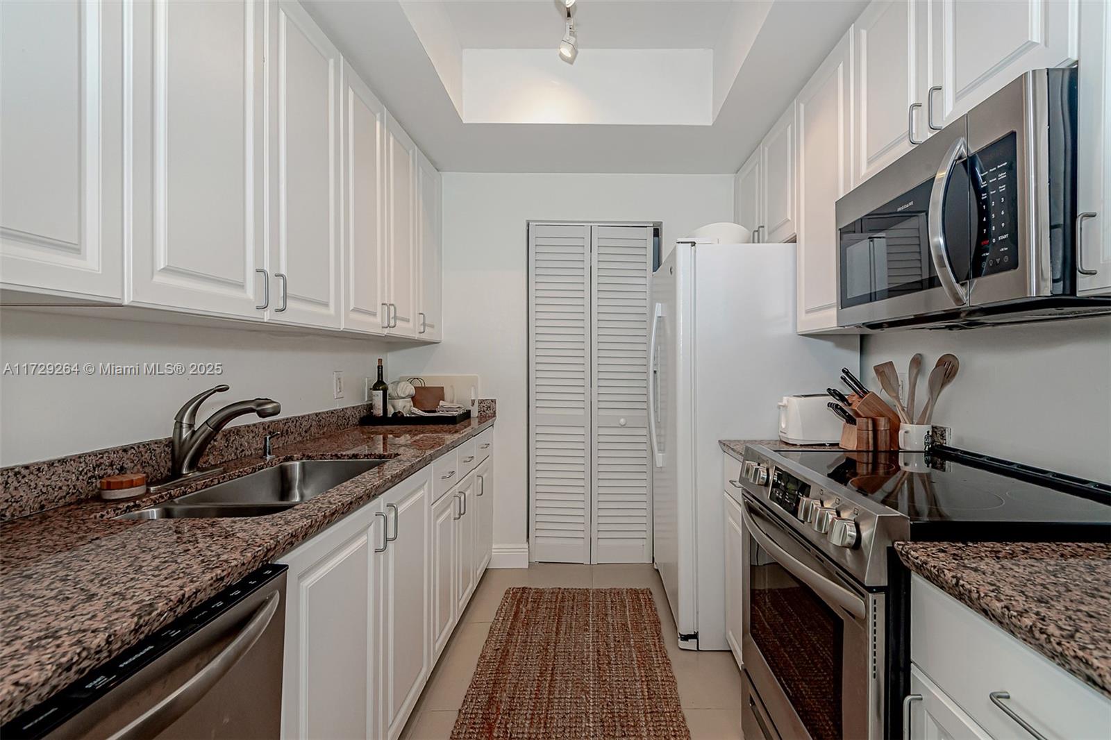 90 Alton Road, Unit PH3205 Miami Beach, FL 33139 - Photo 23 of 28 a kitchen with stainless steel appliances granite countertop a sink stove and cabinets