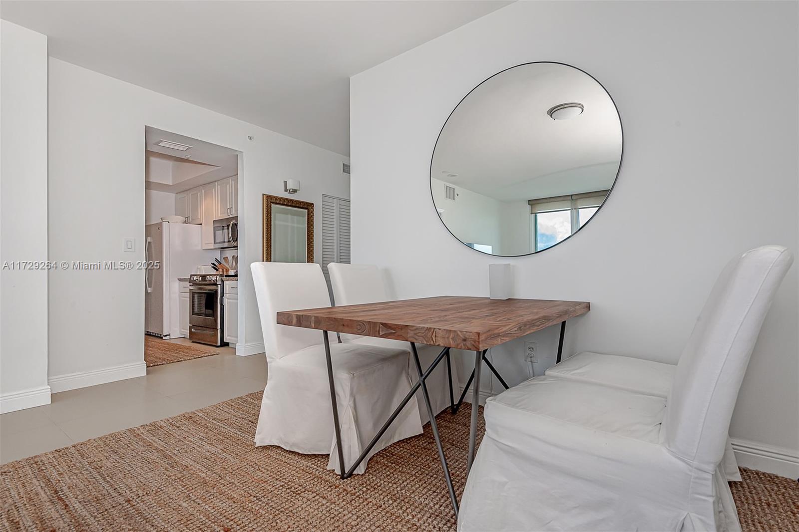 90 Alton Road, Unit PH3205 Miami Beach, FL 33139 - Photo 9 of 28 a room with wooden floor table and a mirror