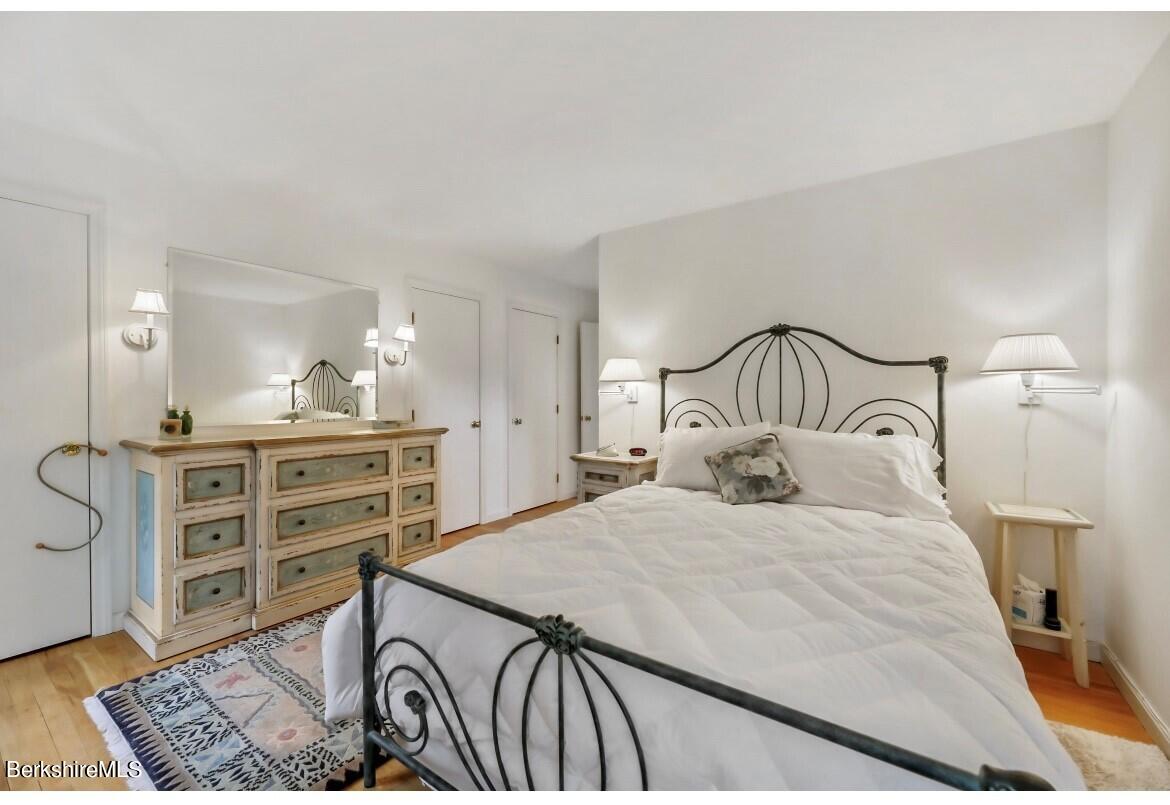 1136 Barker Road, Unit 48 Pittsfield, MA 01201 - Photo 8 of 53 a bedroom with a bed a mirror and lamp
