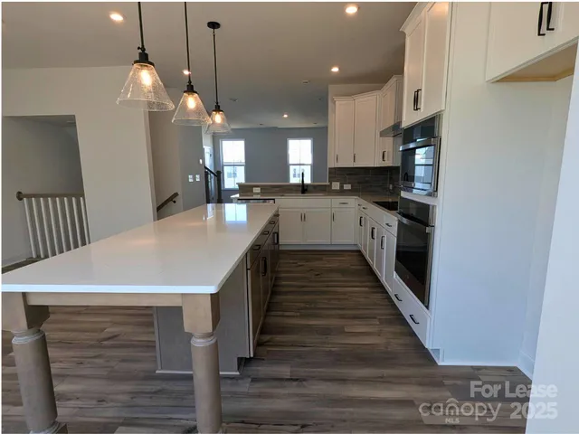 a kitchen with stainless steel appliances a sink a stove a refrigerator a counter top space and cabinets