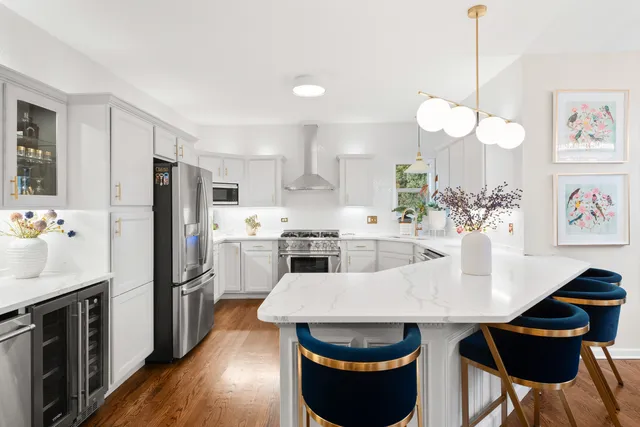 a kitchen with stainless steel appliances a dining table a stove a refrigerator and cabinets