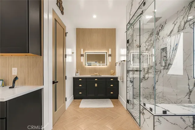 a kitchen with stainless steel appliances kitchen island granite countertop a sink and a flat screen tv