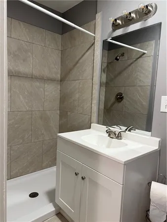 a bathroom with a sink mirror and shower