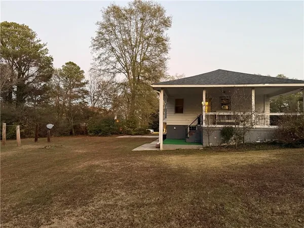 a view of a house with backyard and trees