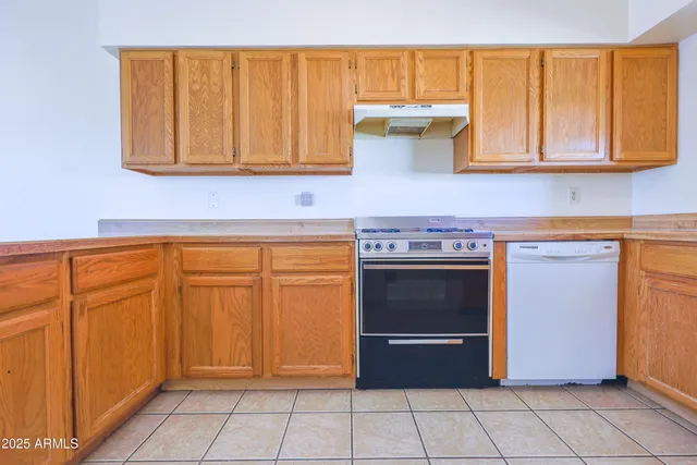 a stove top oven sitting inside of a kitchen