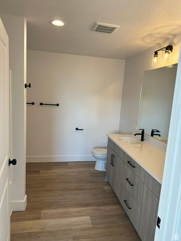 1886 North 300 West Logan, UT 84341 - Photo 16 of 18 Contemporary bathroom featuring wood-finish flooring, a vanity with a light-toned countertop, a built-in sink, tub/shower combination and matte black fixtures