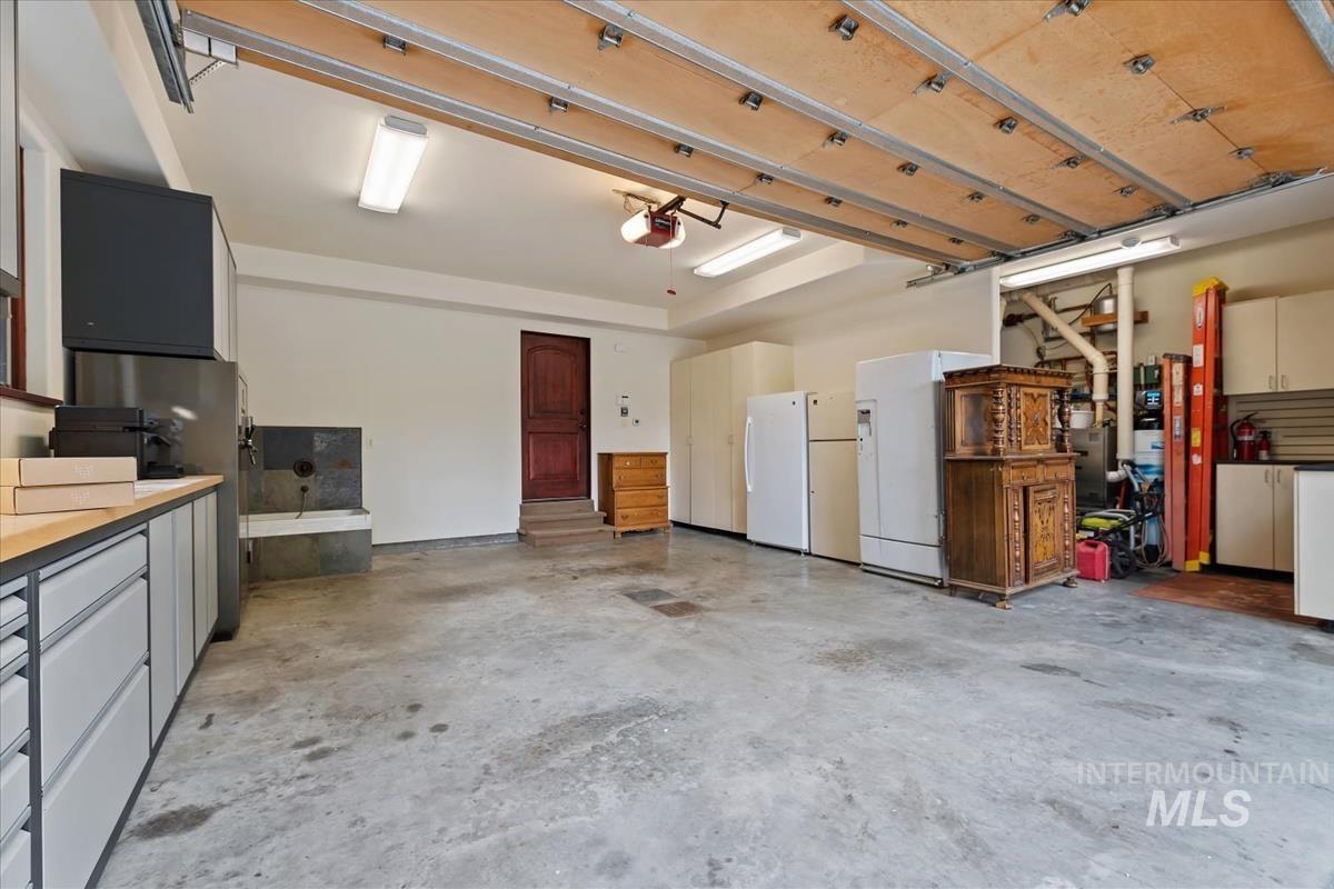 106 Hidden Hollow Road Hailey, ID 83333 - Photo 48 of 49 Concrete flooring, overhead garage door, built-in cabinetry, utilitarian sink, and recessed lighting