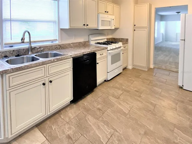a kitchen with granite countertop a sink and cabinets
