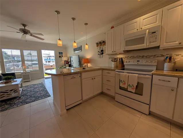 a kitchen with white cabinets and white appliances