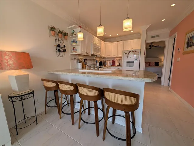 a kitchen with stainless steel appliances granite countertop table chairs sink and cabinets