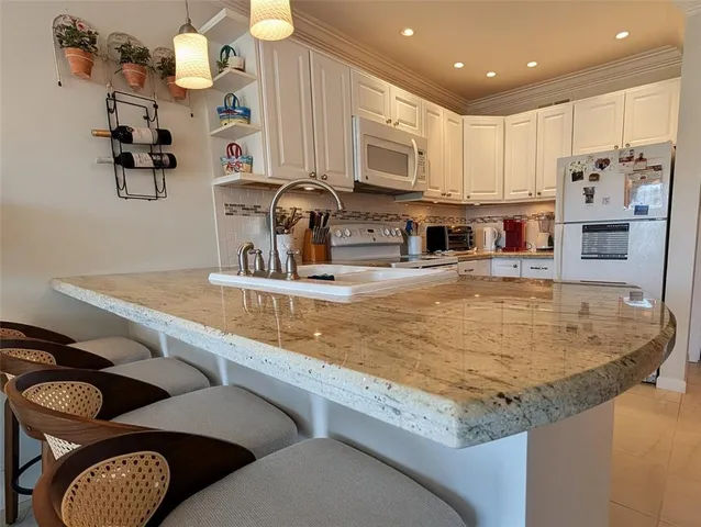 a kitchen with stainless steel appliances granite countertop a sink and a refrigerator