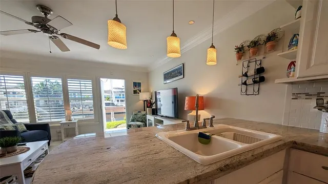 a kitchen with sink and view of living room