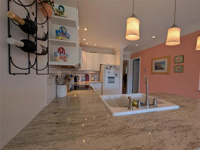 a view of a kitchen with stainless steel appliances granite countertop a sink and a refrigerator