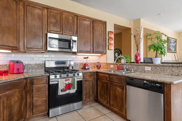 a kitchen with stainless steel appliances granite countertop a stove sink and cabinets
