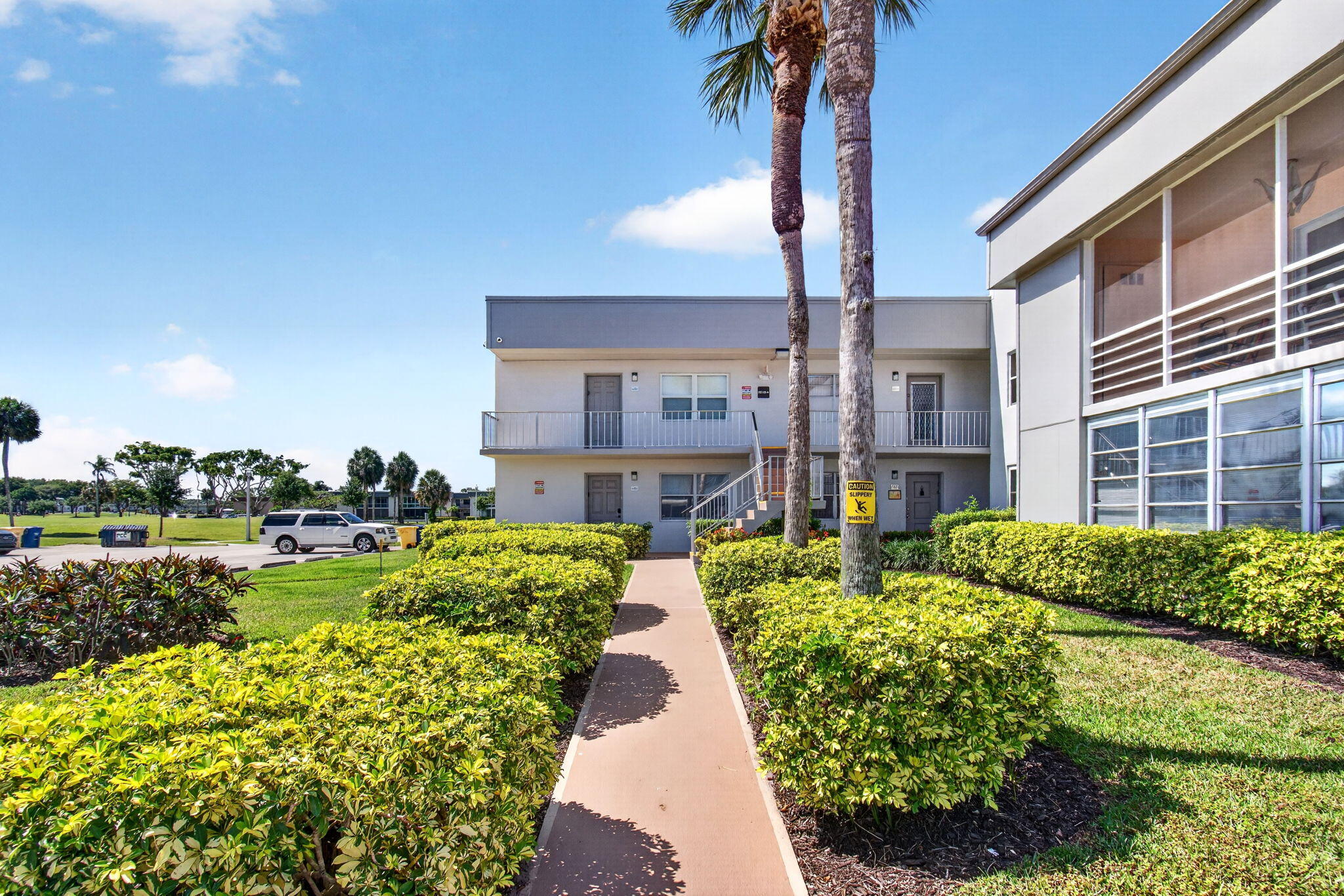167 Normandy Lane, Unit D Delray Beach, FL 33484 - Photo 42 of 46 Palm Tree Lined Walkway