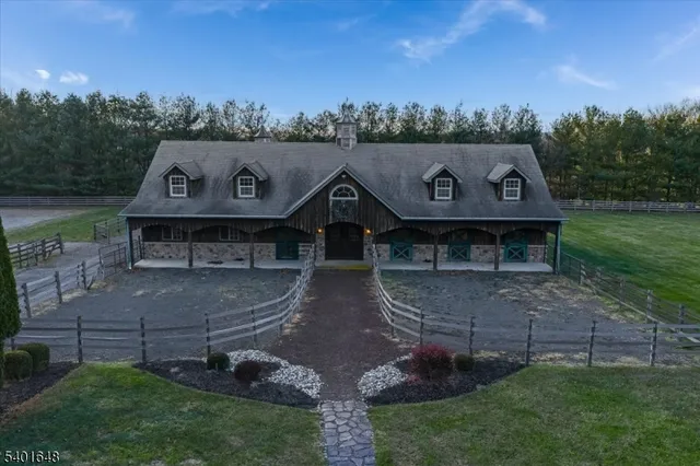 a front view of a house with lots of trees and plants