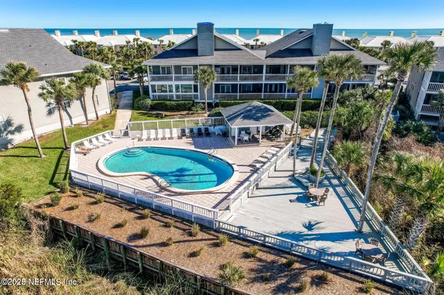 an aerial view of a house with swimming pool and patio
