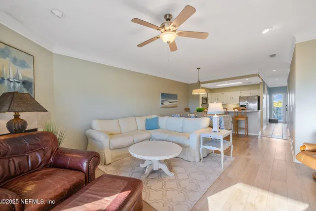 a living room with furniture a chandelier fan and a rug