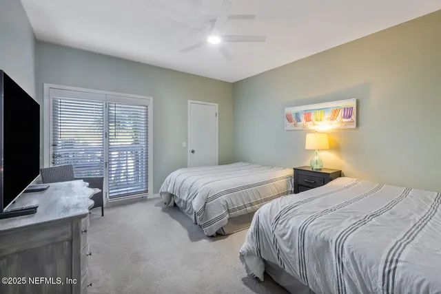 a bedroom with two beds and a flat screen tv