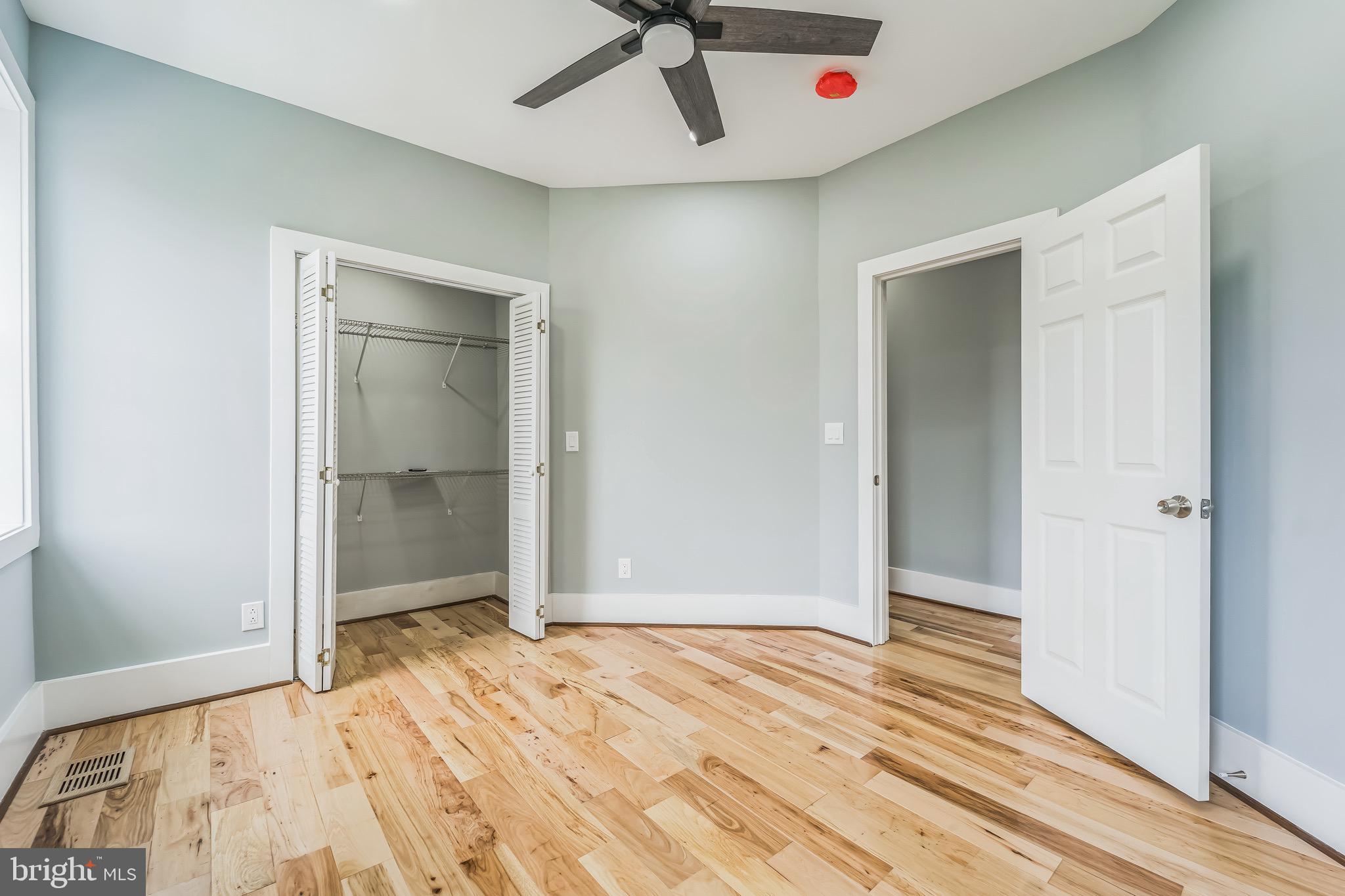 1036 Poplar Grove Street Baltimore, MD 21216 - Photo 17 of 24 an empty room with wooden floor and ceiling fan