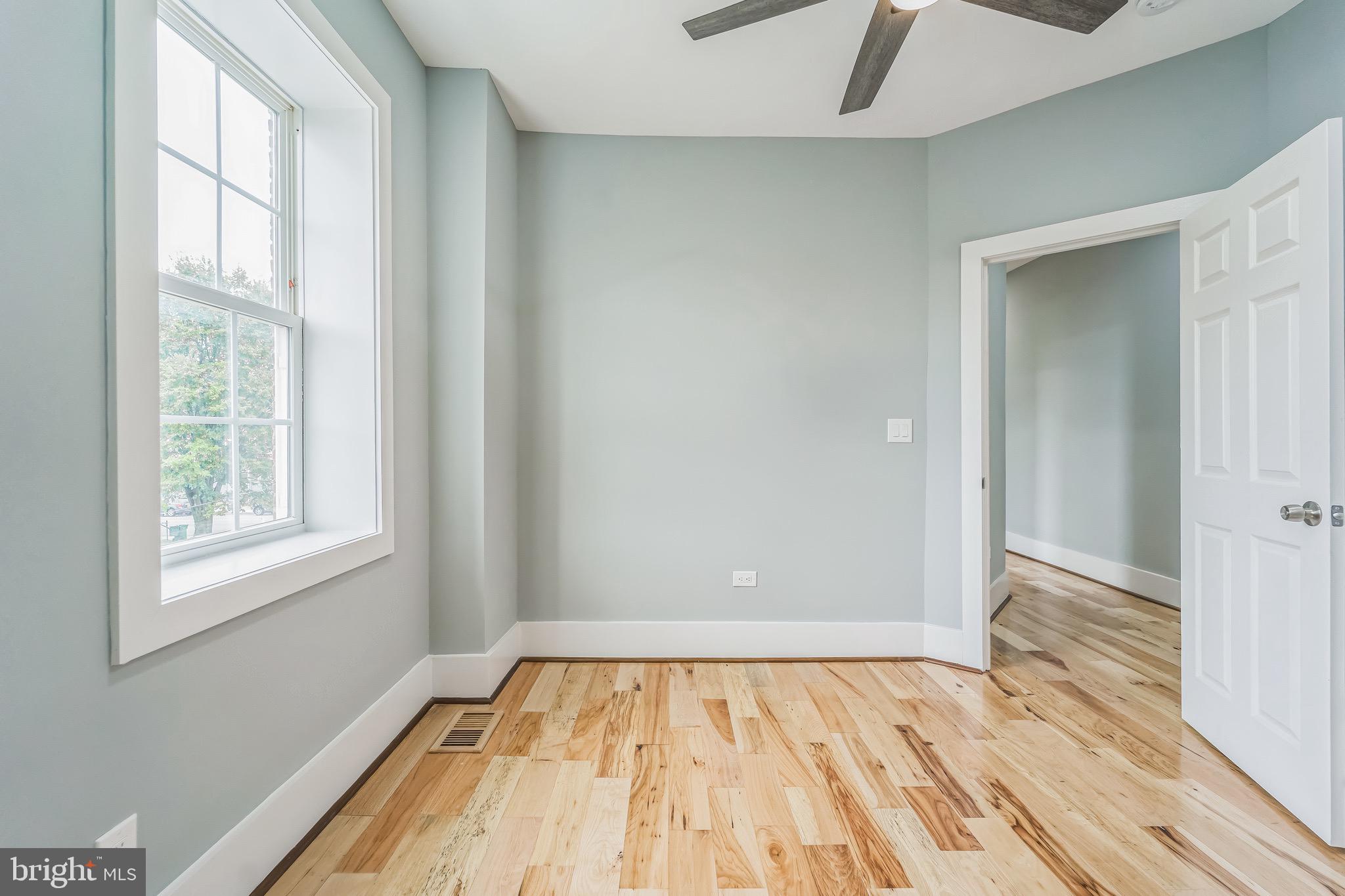1036 Poplar Grove Street Baltimore, MD 21216 - Photo 21 of 24 an empty room with wooden floor and windows
