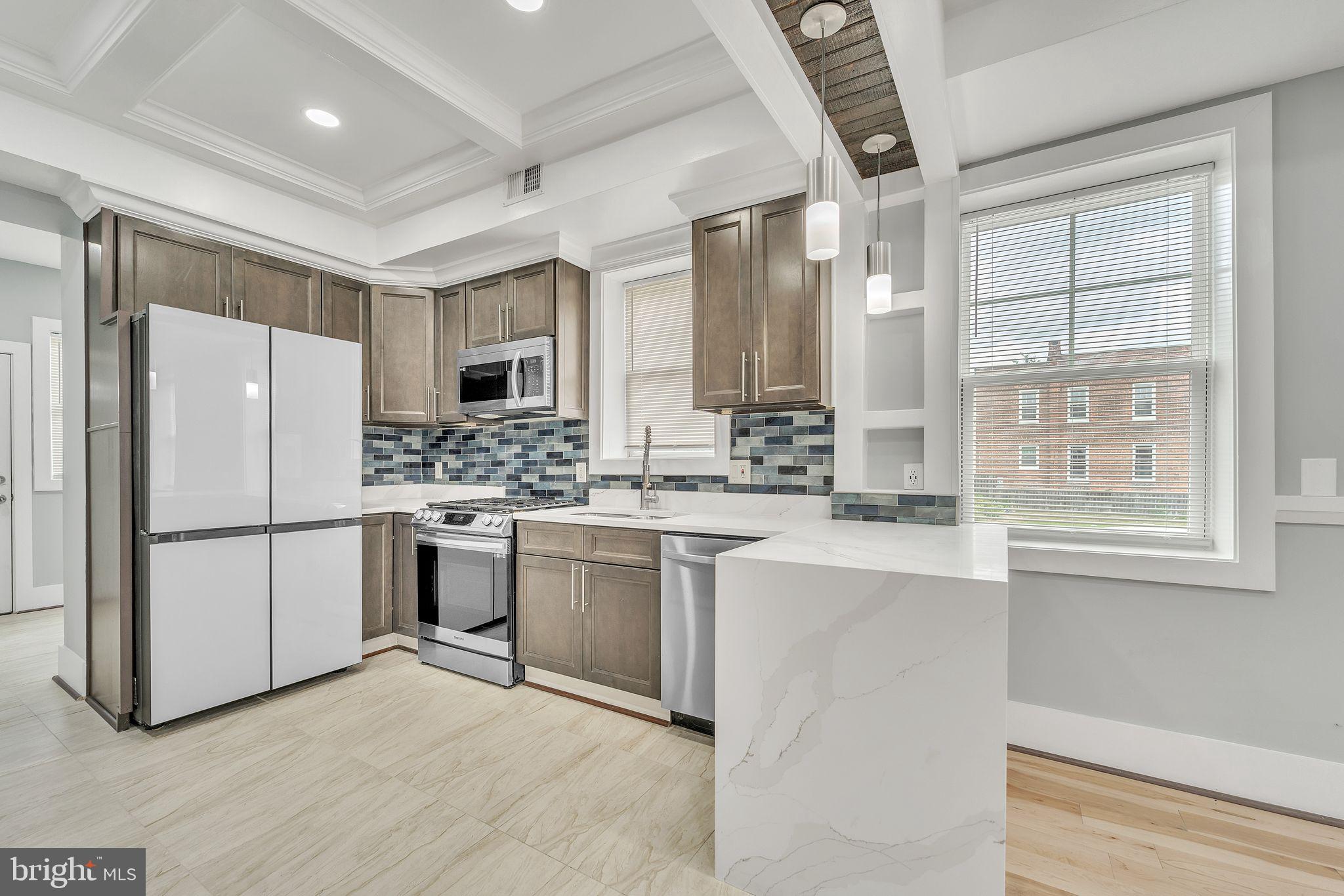 1036 Poplar Grove Street Baltimore, MD 21216 - Photo 6 of 24 a kitchen with a refrigerator a stove a sink and a window