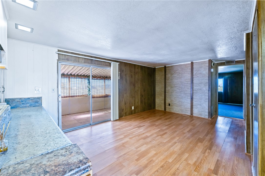 3475 Adobe Road Golden Valley, AZ 86413 - Photo 13 of 71 Unfurnished dining area with light wood finished floors, a textured ceiling, and wooden walls