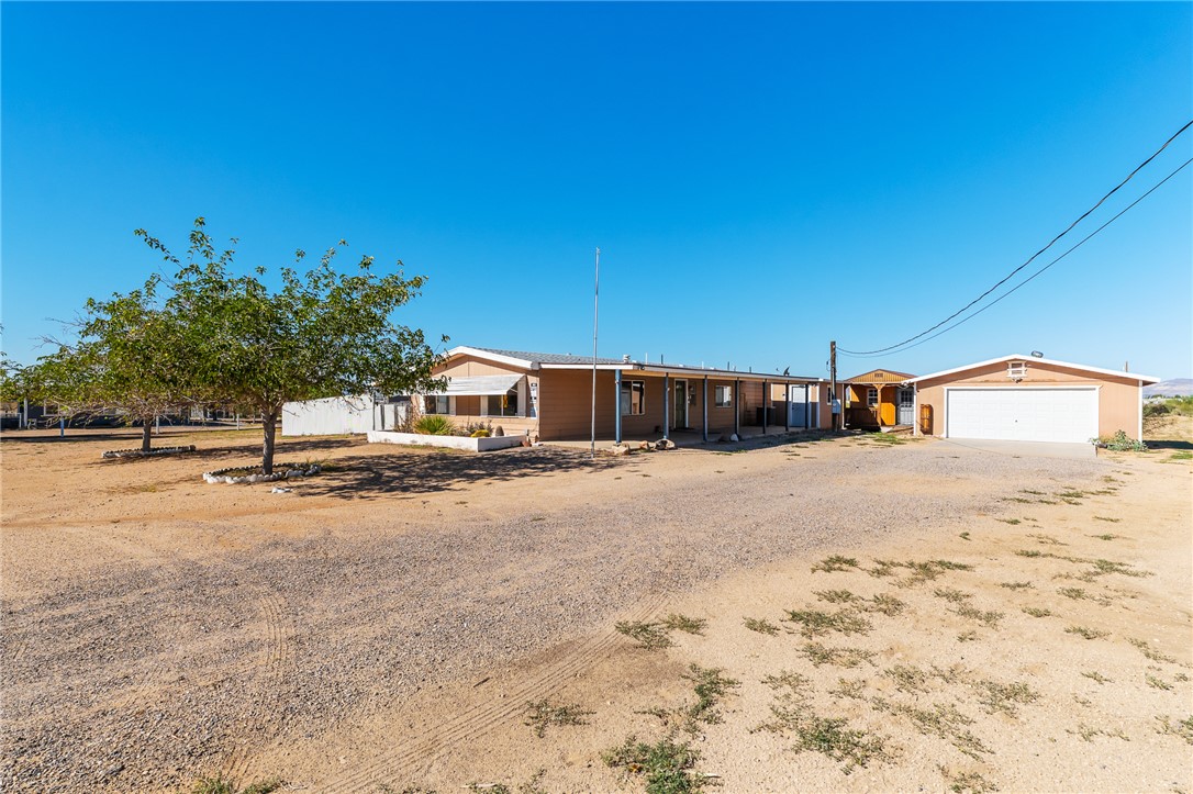 3475 Adobe Road Golden Valley, AZ 86413 - Photo 2 of 71 View of front of property with a garage, driveway, and a porch