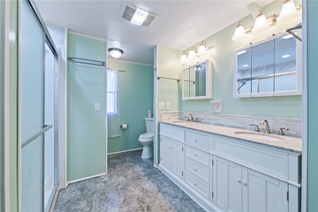 3475 Adobe Road Golden Valley, AZ 86413 - Photo 28 of 71 Bathroom featuring double vanity, a shower stall, and decorative???????????????????????????????? backsplash
