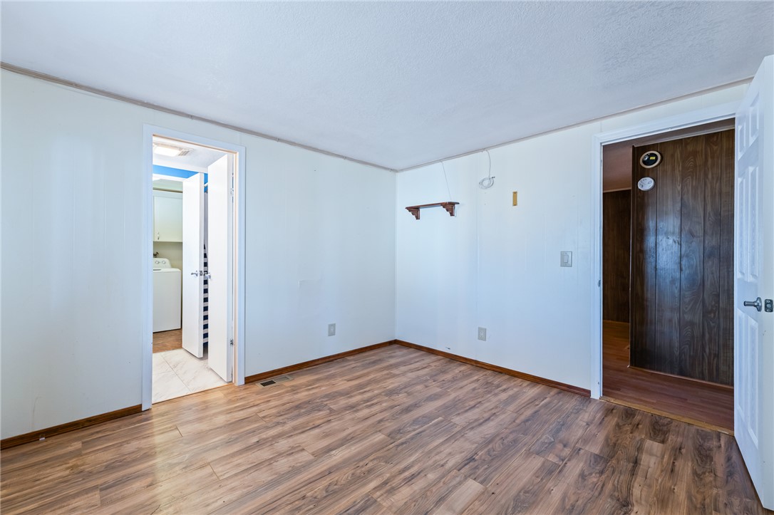 3475 Adobe Road Golden Valley, AZ 86413 - Photo 33 of 71 Unfurnished bedroom with wood finished floors and washer / dryer