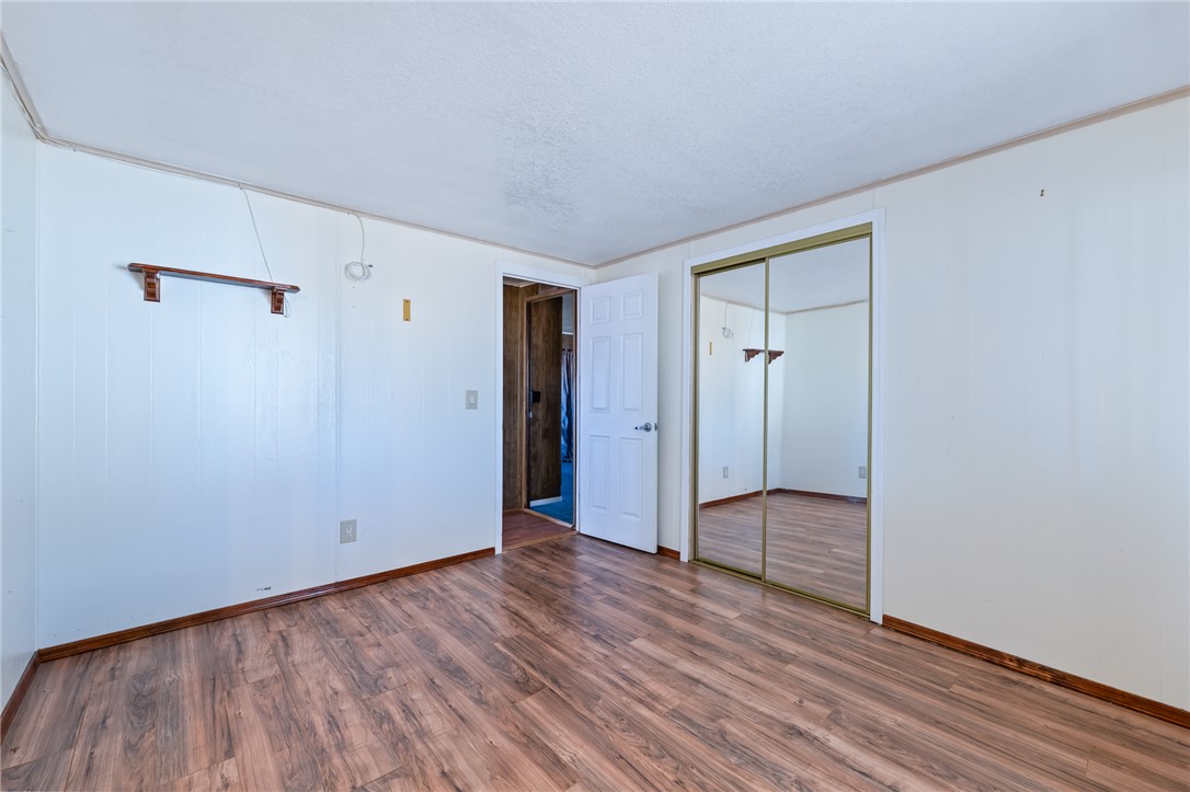 3475 Adobe Road Golden Valley, AZ 86413 - Photo 34 of 71 Unfurnished bedroom with wood finished floors, a closet, and a textured ceiling