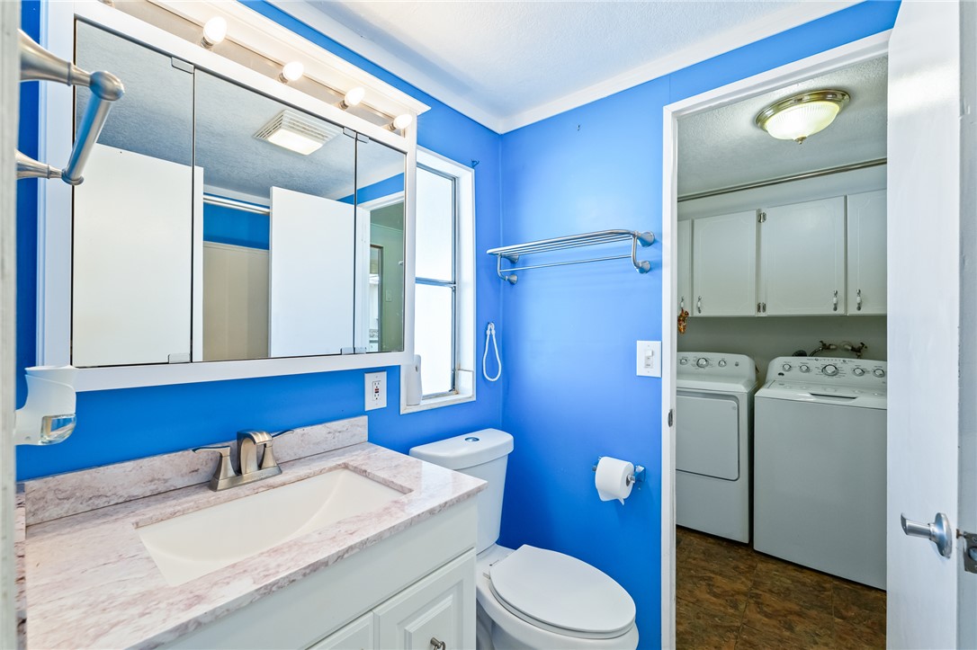 3475 Adobe Road Golden Valley, AZ 86413 - Photo 35 of 71 Half bathroom featuring vanity, washing machine and dryer, and a textured ceiling