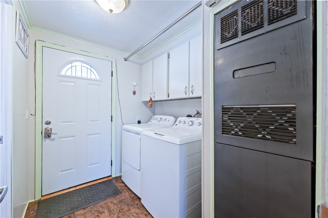 3475 Adobe Road Golden Valley, AZ 86413 - Photo 38 of 71 Laundry area featuring stone finish flooring, cabinet space, washer and clothes dryer, and a textured ceiling