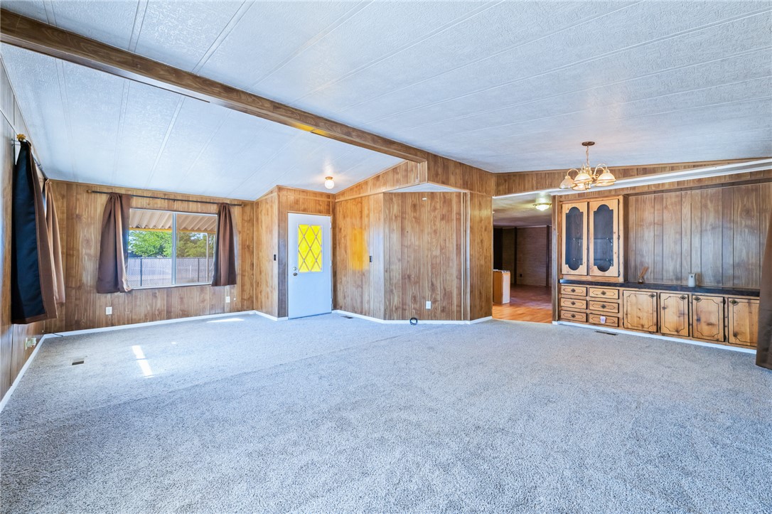 3475 Adobe Road Golden Valley, AZ 86413 - Photo 9 of 71 Unfurnished living room with wood walls and carpet floors