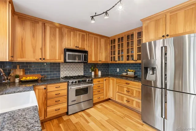 a kitchen with stainless steel appliances granite countertop a refrigerator stove top oven and sink