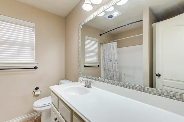 a bathroom with a sink toilet vanity and shower