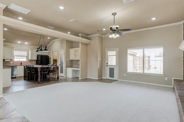 an empty room with furniture and a large window