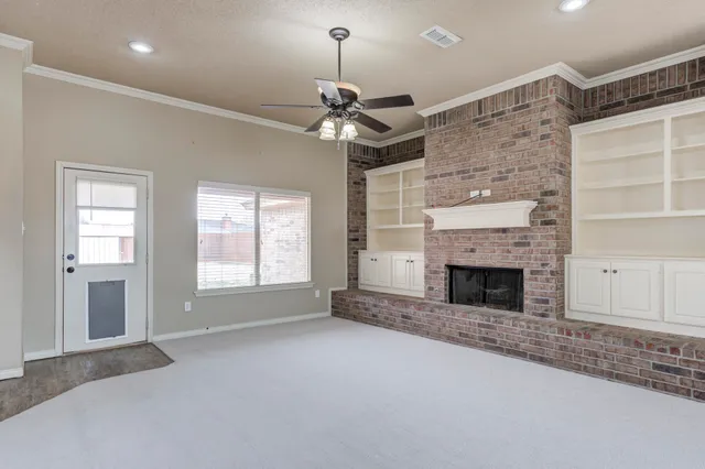 a view of a livingroom with a fireplace and chandelier fan