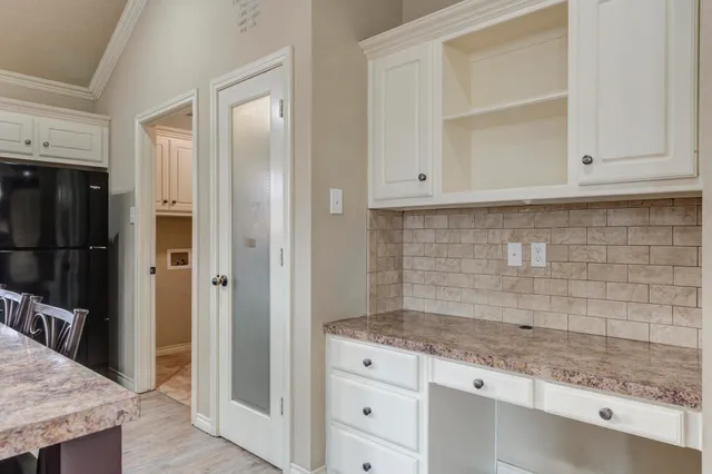 a kitchen with granite countertop white cabinets and stainless steel appliances