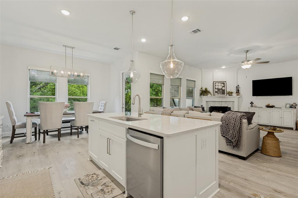1508 Bear Path Way Gunter, TX 75058 - Photo 7 of 25 a large kitchen with kitchen island stainless steel appliances a stove a sink a dining table and chairs