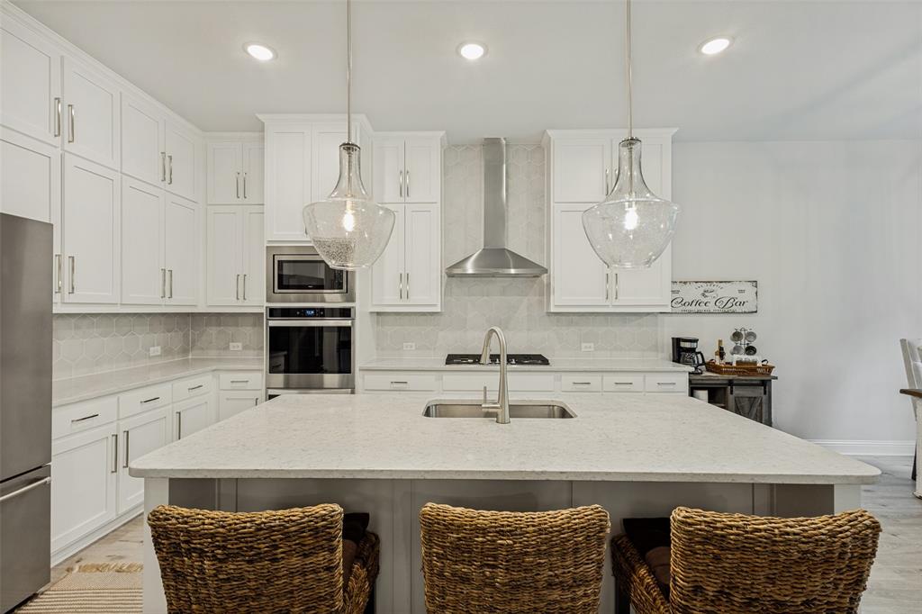1508 Bear Path Way Gunter, TX 75058 - Photo 8 of 25 a kitchen with stainless steel appliances granite countertop a sink a stove and a refrigerator
