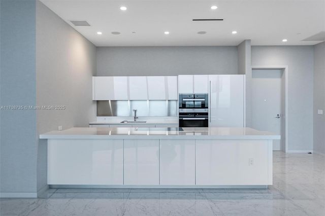 a kitchen with kitchen island cabinets and oven