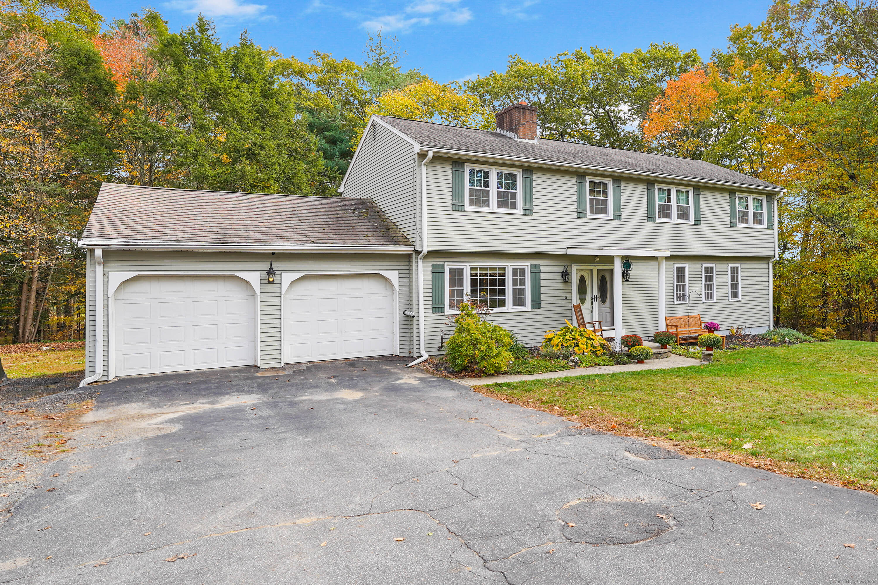a view of a house with a yard and a large tree