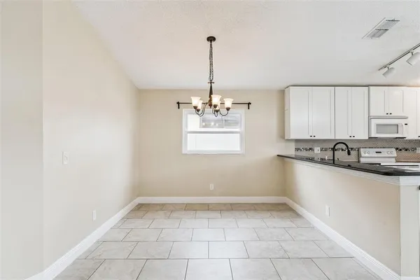 a kitchen with stainless steel appliances granite countertop a sink a stove a refrigerator a microwave and cabinets