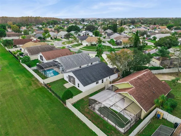 an aerial view of a house with green landscape and water view